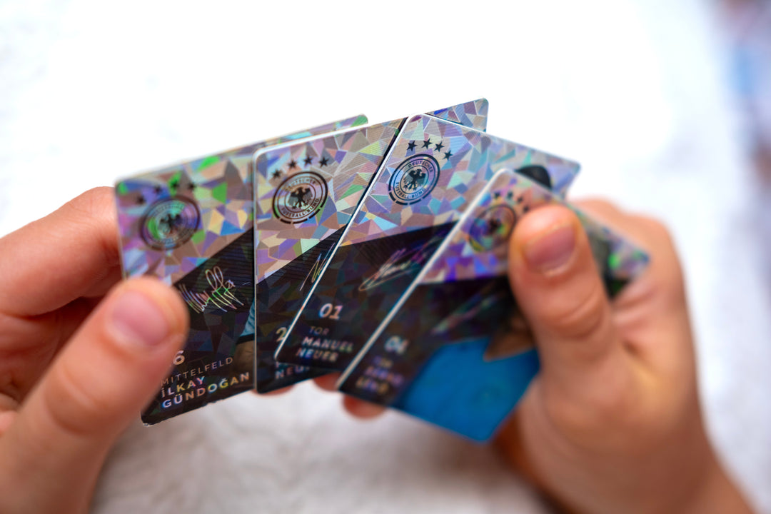 Child holding holographic Trading Cards and Collectable Card Collections showcasing popular players.