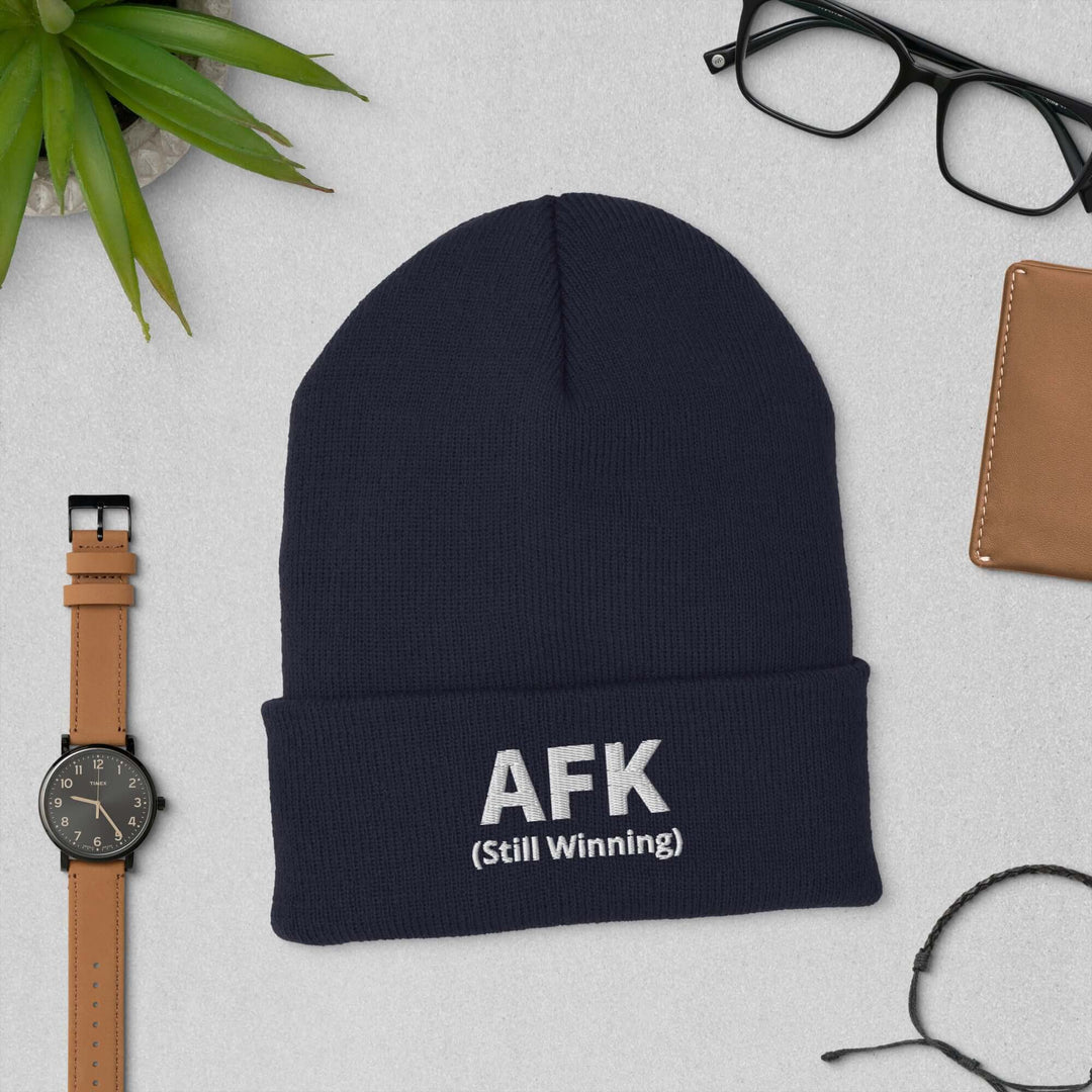 AFK Cuffed Beanie displayed on a table with accessories including a watch, glasses, and a wallet.