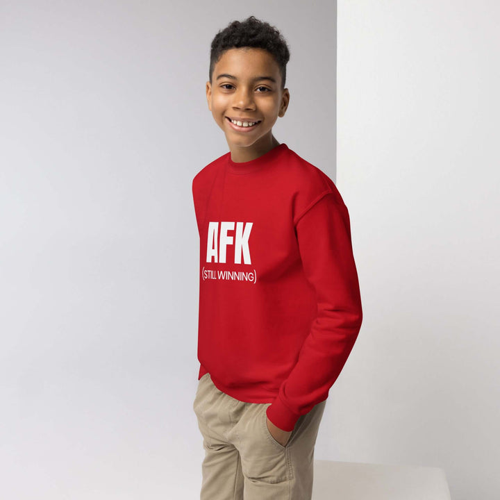 AFK Youth crewneck sweatshirt in red worn by a smiling boy, stylish and comfortable for any adventure.